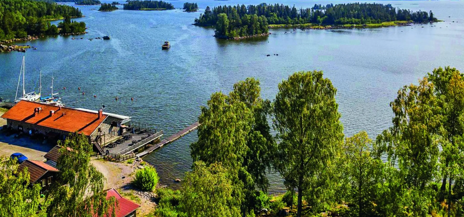 Kustbandet med restaurang i förgrunden en fin sommardag