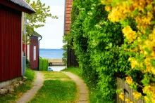 Sommarväg mellan röda små hus på väg mot havet